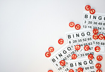 Many wooden chips with numbers and cards for a board game of bingo or lotto on a light background.