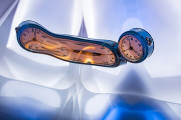 Art. Creative. A blue table clock reflected on a distorted mirror.