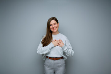 Smiling woman holding hands on chest. Isolated female portrait