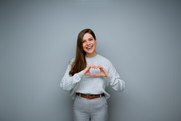 Smiling woman making heart shape with her hands. - 583990083