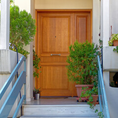An elegant family house entrance with a natural brown wood door. Travel to Athens, Greece.