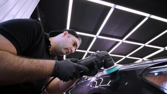 Professional car detailing using machinery and polishers for paint restoration.
