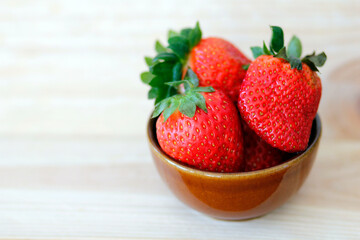 fresh strawberries in a  ceramic bowl on wooden background with space for text, healthy strawberry fruits, summer fruit