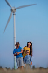 Girl and boys in front of windmills. Children playing near wind turbine. Renewable energies and sustainable resources wind mills.