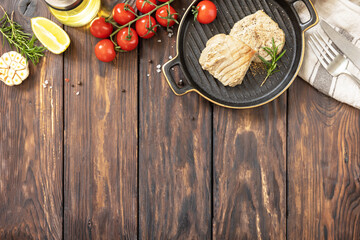 Cooked juicy tuna steak  with spices, tomatoes and rosemary on a stone plate. Restaurant food. Seafood. Rustic style. View from above. Copy space.