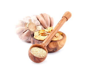 Garlic in closeup on white background. Garlic powder in wooden spoon. Garlic slices.