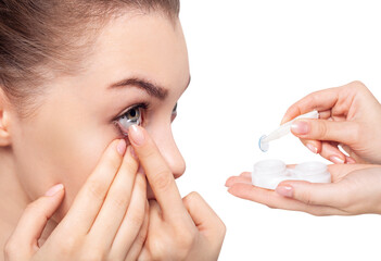 Young woman wearing contact lenses from container.