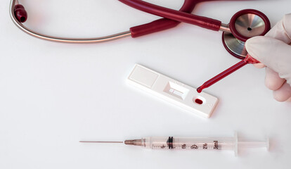 Scientist or doctor placing blood sample on RDT rapid diagnostic cassette, medical technician doing...