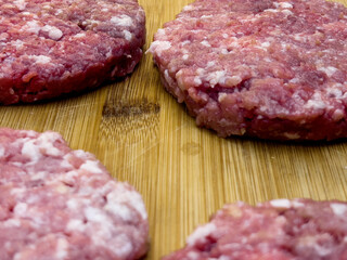Meat cheese burgers for hamburger lie on a wooden board.