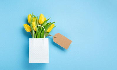Holiday Spring Yellow Tulip Flowers Bouquet and Tag on Blue Background.