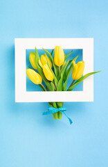 Holiday Yellow Tulip Flowers Bouquet for Mothers Day on Blue Background.