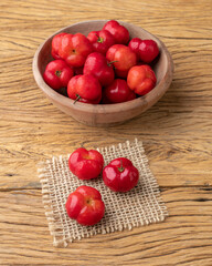 Acerolas or Barbados Cherries in a bowl over wooden table
