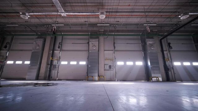 Construction process of a big, modern warehouse with multiple garage gates for easy access and transportation of goods.