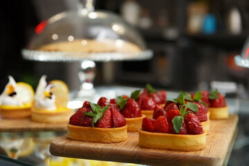 Delicious strawberry tarts decorated with fresh mint leaves. Gourmet desserts cooked with shortbread and fresh strawberries for lunch in pastry cafe