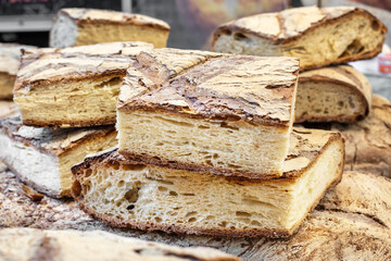 A loaf of bread cut into large pieces close-up, flour bakery products, street food. Organic food. Healthy eating