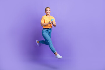 Fototapeta na wymiar Full length profile photo of excited person jump rush hold telephone isolated on violet color background