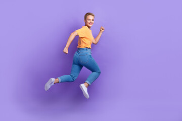Fototapeta na wymiar Full size photo of cheerful satisfied nice girl wear sneakers denim pants rush at sale shopping isolated on purple color background