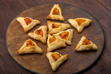 Sweet gomentashi cookies for the Jewish holiday of Purim on a chalkboard are laid out in the form of Magen David on the table.