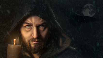 mysterious man or Catholic monk with candle in a raincoat hood fine art photo