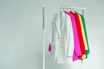 Multi-colored bright jackets on a hanger on a white background.