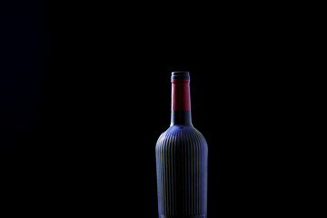 One empty wine bottle against a dark background