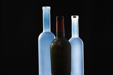 Empty liquor bottles on black background .