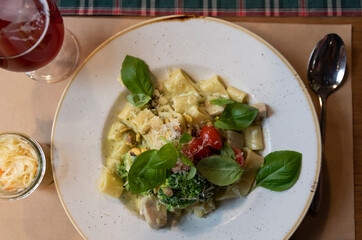 Pasta with chicken and sauce on a plate and salad with vegetables on dinner in restaurant. Helathy food for eating. Top view.