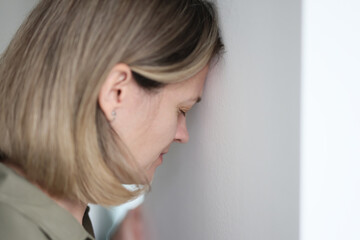 Desperate woman blunts against wall worrying about problems - obrazy, fototapety, plakaty
