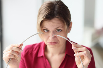 Woman frowns holding broken local network wire with hands