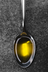 A spoonful of organic olive oil on vintage background