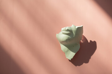 A fragment of an antique sculpture, a piece of a face on a pink background