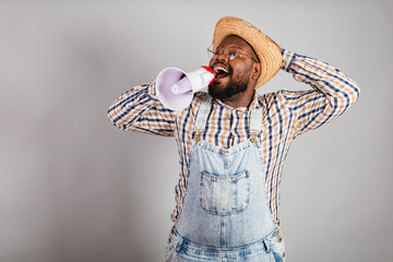 brazilian black man wearing country clothes from festa junina, festa de são joão. arraiá, using...