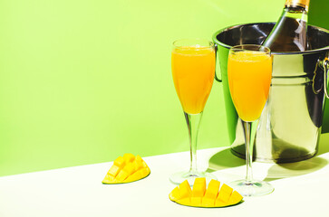Mango bellini alcoholic cocktail drink with prosecco or champagne, mango puree, syrup and ice....