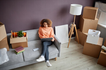 High angle view of young woman using laptop while sitting on sofa in the room at home