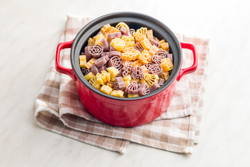 Pasta of various scary shapes. Uncooked halloween pasta in pot.