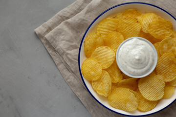 Tasty Potato Chips and Dip Appetizer on a gray background, top view. Space for text.