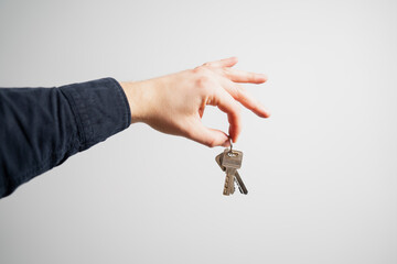 Man hand holding key chain in tip of fingers on white clear background