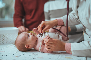 Obraz na płótnie Canvas Doctor pediatrician and baby patient. Medical checkup. Doctor pediatrician examining little baby with stethoscope in clinic. 