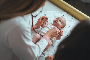 Doctor hands use stethoscope to check newborn baby health and take care him or cure the disease or disorder. Close up of pediatrician hand using a stethoscope to listen and checking heartbeat.