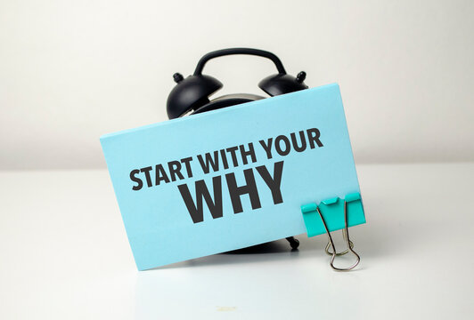 start with your why is written in a blue sticker near a black alarm clock