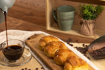 Argentinian breakfast. Croissants. Serving coffee in cup. Coffee beans. Still life.