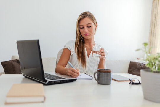 Cropped shot of a businesswoman making notes at her desk in a modern office.