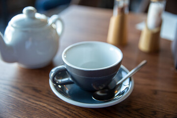 Fototapeta premium Teapot and cup and saucer on the table in restaurant
