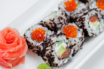 Japanese sushi with salmon, Philadelphia cheese, avocado in white rice and flying fish roe with salmon caviar