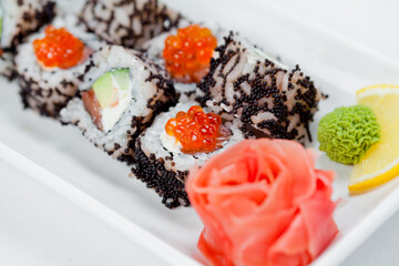 Japanese sushi with salmon, Philadelphia cheese, avocado in white rice and flying fish roe with salmon caviar
