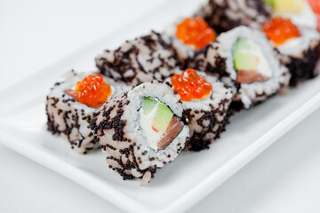 Japanese sushi with salmon, Philadelphia cheese, avocado in white rice and flying fish roe with salmon caviar