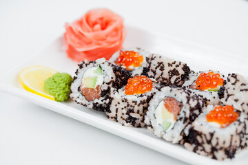 Japanese sushi with salmon, Philadelphia cheese, avocado in white rice and flying fish roe with salmon caviar