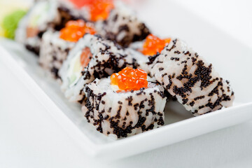 Japanese sushi with salmon, Philadelphia cheese, avocado in white rice and flying fish roe with salmon caviar