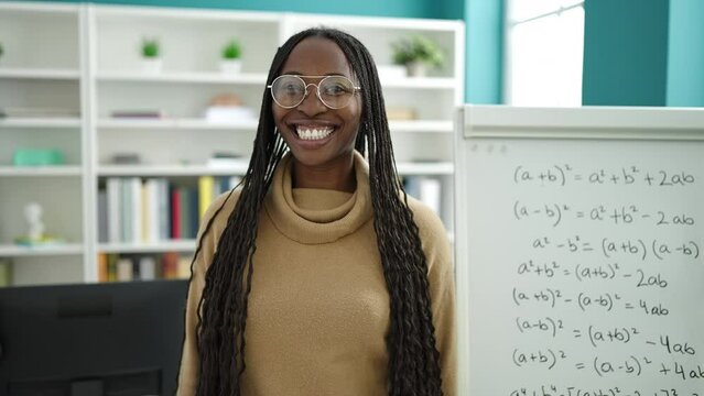 African woman smiling confident by maths magnetic board at library university