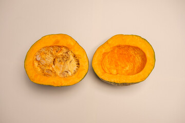 A juicy organic pumpkin cut in half on a white background. Seasonal food typical of autumn